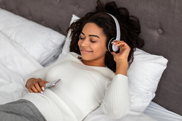Satisfied young black woman listening to music