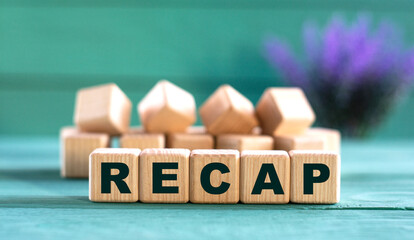 RECAP - word on wooden cubes on a green background with lavender