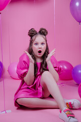 Obraz na płótnie Canvas pretty brunette girl teenager with blue eyes and pink make up among balloons on pink background. party, birthday, holiday