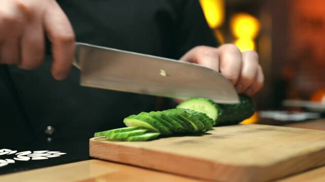 Slicing of a cucumber in the restaurant kitchen