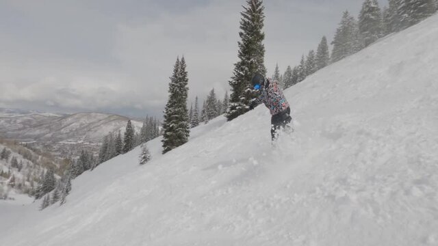 Fearless man on snowboard down steep slope, Aspen, Colorado. Winter extreme sports.