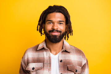 Photo portrait of bearded man wearing brown checkered shirt smiling isolated on bright yellow color background