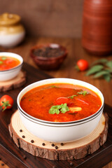 Tomato rasam curry hot spicy soup South Indian cuisine prepared using Indian spices, tomato tamarind , chili, cumin. Traditional vegetarian dish rice onam sadhya Kerala, Tamil Nadu, India Sri Lanka.