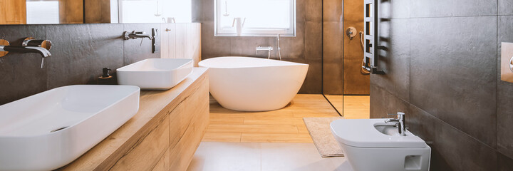 Stylish bathroom with wooden and concrete walls and white bath - 430640097