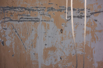 silver drips and runs on a detail of a scratched steel door with peeling white paint