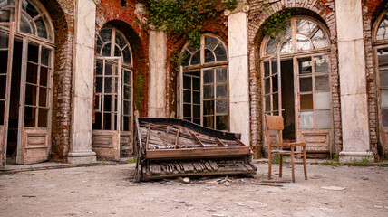 Fototapeta na wymiar Destroyed piano in an abandoned palace.