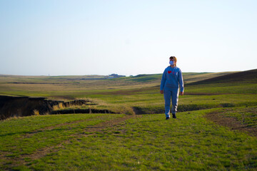Girl on a walk, along the river bank, spring evening. In individual protection against coronavirus.