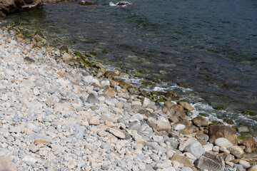 Close up of rocks in the sea with green moss and tranquil water