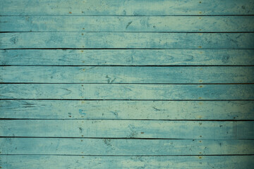 Background of an old wooden fence in turquoise or green. Pastel delicate shade. The texture of the painted old wood