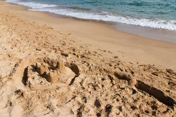 Sand castle on the beach with the sea in the back
