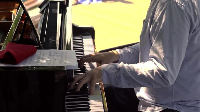 a pianist plays the piano at a picnic in a secular society