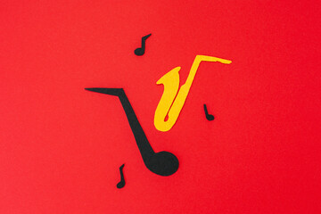 International Jazz Day. Silhouette of a saxophone and note with melodies on a red background,...