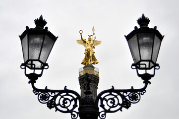 Fototapeta na wymiar old street lantern in with Berlin Victory Column
