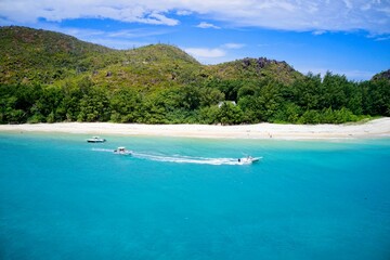 Drone field of view of speeding boat in turquoise water Curieuse Island, Seychelles.