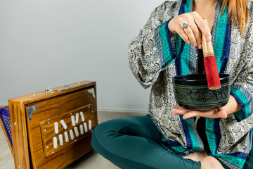 Woman playing a Tibetan singing bowl, music therapy. Woman performing kirtan, chanting mantras.