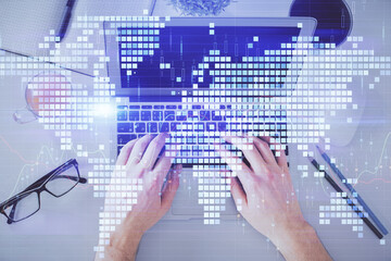 Double exposure of man's hands typing over computer keyboard and business theme hologram drawing. Top view. Financial markets concept.