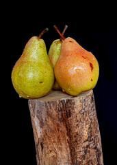 Fototapeta na wymiar Three colorful pears on wood