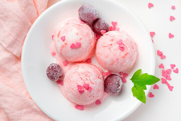 Cherry ice cream with frozen berries on a light background.