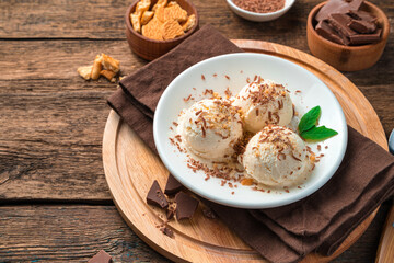 Chilled summer dessert, creamy ice cream on a brown background.