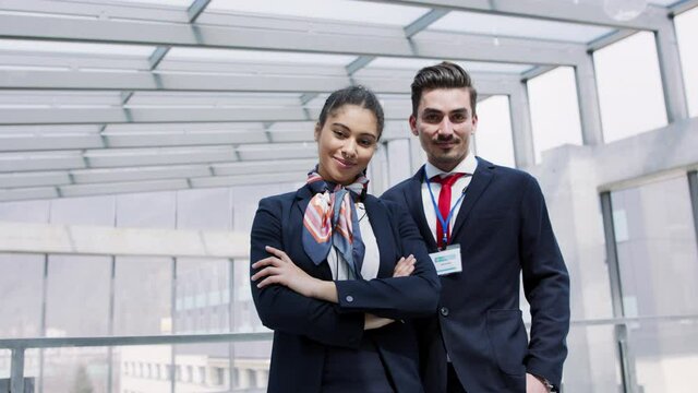 Front view of young stewards in airport, looking at camera.