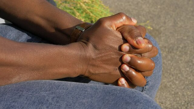 helplessness, anger - black man's hands clench tightly symbolizing helplessness