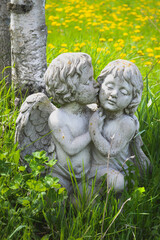 Statue of Cherubs in Green Field with Yellow Flowers in Background