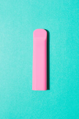 Colorful disposable electronic cigarette pod on a blue background. alternative to modern smoking, vaping and nicotine. tobacco substitution rose