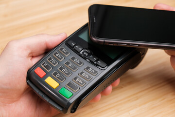 Man uses wireless terminal contactless payment with smartphone