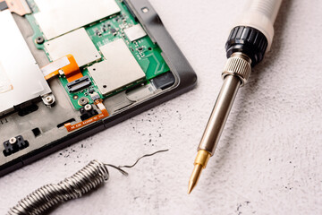 Home repair of an electronic device with a homemade tin soldering iron.