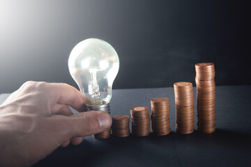 glowing lamp and coins in the form of diagrams