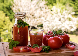 frische tomaten mit tomatensaft auf der terrasse mit blick auf blühende kirschbäume