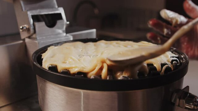Grilled Belgian waffles. Dough is poured into a waffle iron to make a waffle. Homemade baking and cooking of Belgian fresh waffles. Slow motion