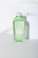 Facial cleanser bottle. Lotion or micellar water for face cleansing. Liquid cosmetic product in green packaging. Natural cosmetics concept