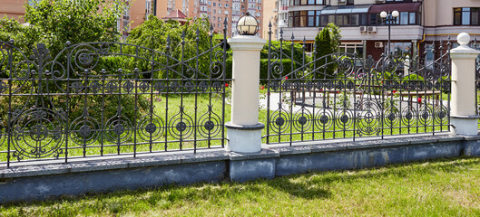 Wrought iron fence. Image of a Beautiful decorative cast iron wrought fence with artistic forging...