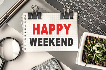 HAPPY WEEKEND text on a notepad and laptop, office tools. Business, financial concept. remote training. Coffee break, ideas, notes, goals or writing a plan, invitation concept. Top view, flat lay.