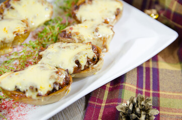 baked potatoes stuffed with meat and melted cheese on the Christmas table