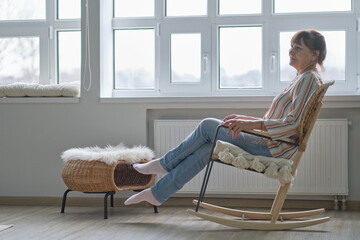 elderly woman sits in a wicker rocking chair. woman resting in armchair. Joy of life