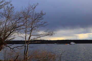 One big boat or ship at the horizon outside. Sunset.Dramatic weather during spring. Plenty of multicolored clouds. Copy space for text. Stockholm, Sweden, Europe.