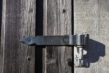 Hinge on a old wooden door. Outside during the day. Close up and isolated. Stockholm, Sweden.