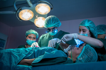 Team of professional surgeons and nurses suture wound after successful surgery in surgery room.