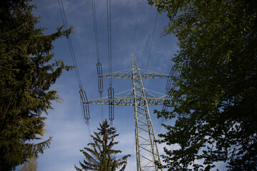 power pylon with power wires, blue sky as background, view from below