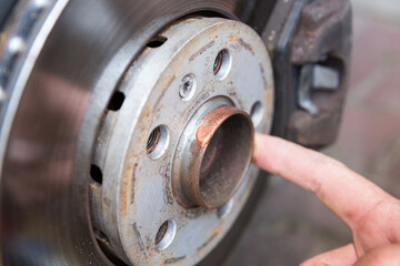 Car mechanic applying copper grease on a car hub