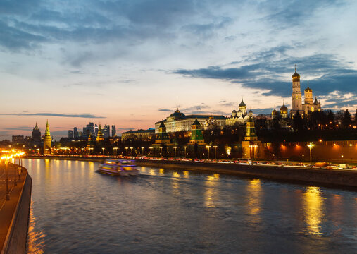 The Moscow Kremlin in sunset. River, ship sailing.