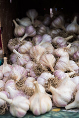 Heads of garlic spill from a crate on to a table.