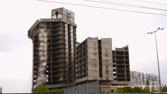Old building demolition by controlled implosion using explosives.