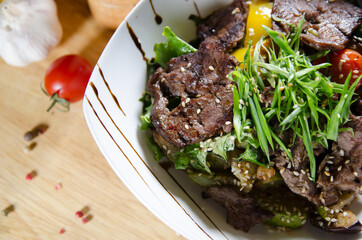 meat with vegetables in a white plate flat lay closeup 