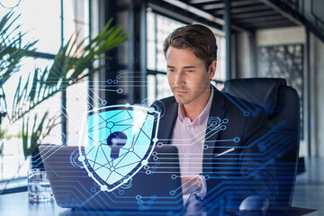 Handsome businessman in suit at workplace working with laptop to defend customer cyber security....