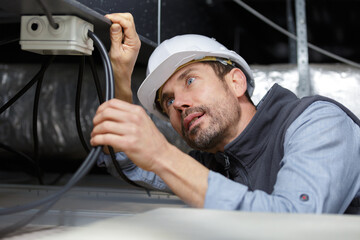 electrician fixing neon on the ceiling