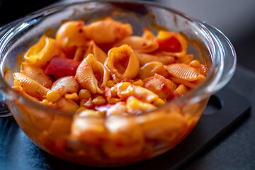 Close up and selective focus on a pasta bake straight out of the oven with intentional shallow depth of field and bokeh
