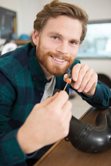 mechanic using screwdriver to assemble part in workshop